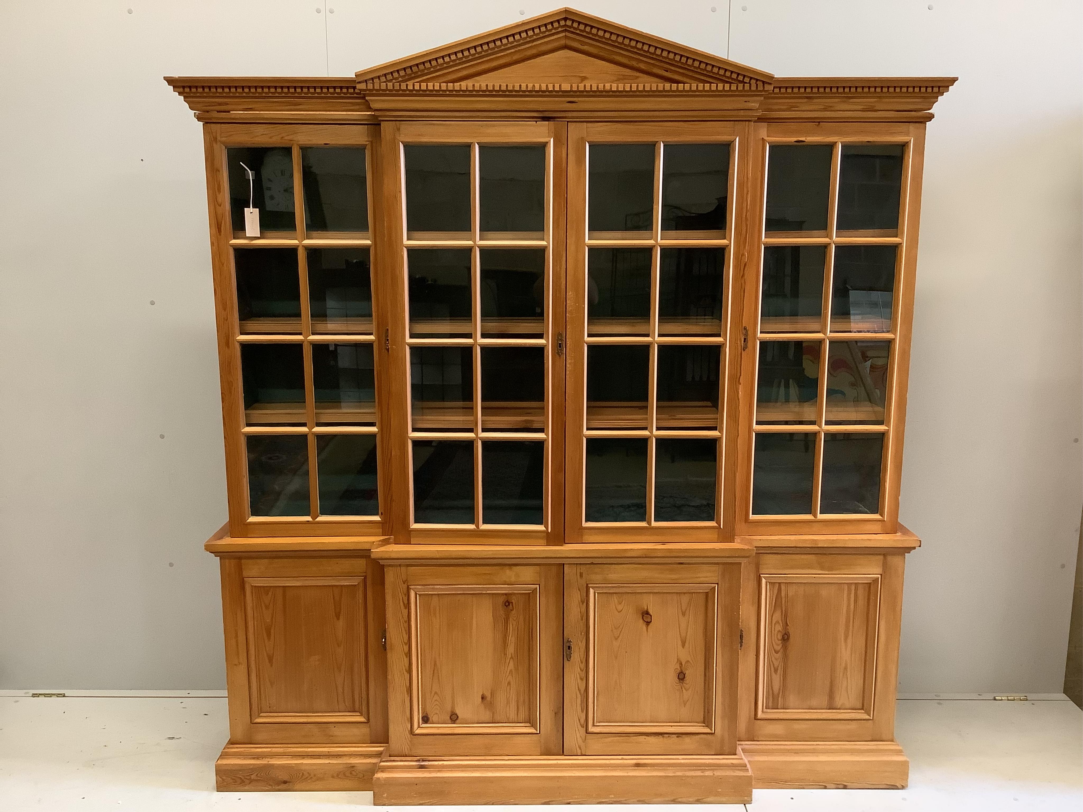 A modern pine breakfront bookcase, width 194cm, depth 44cm, height 207cm. Condition - fair to good